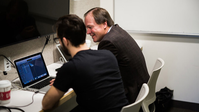 Student and professor working on a laptop in an Allen Library listening room..